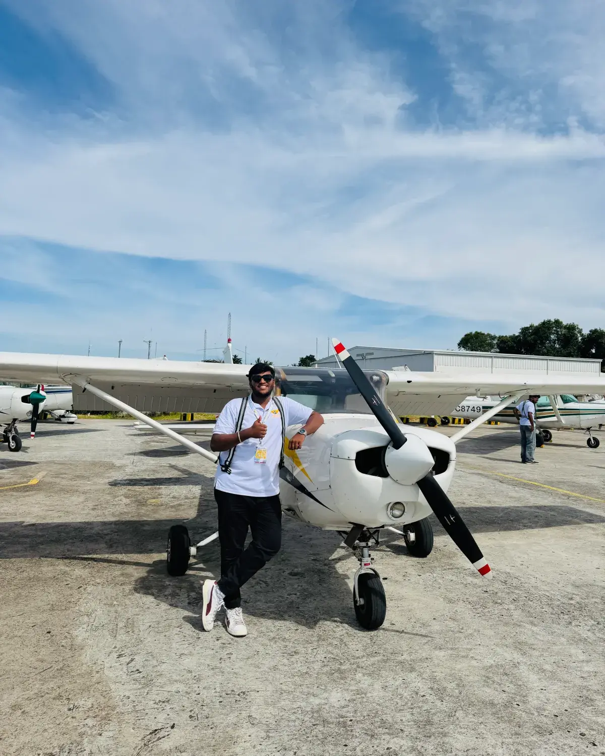 A Lycoming Aviation cadet beside a Cessna trainer on the apron